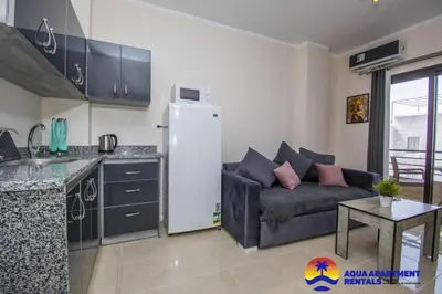 a kitchen and a living room with a couch and a refrigerator at Aqua Tropical Apartment Near El Gouna in Hurghada