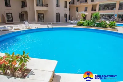 a large blue swimming pool in front of a building at Aqua Tropical Apartment Near El Gouna in Hurghada