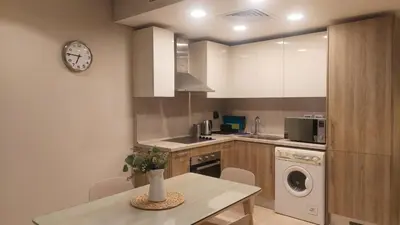 a kitchen with a table and a clock on the wall at Mangroovy Beach Front - 1 BR - Free Beach & Pool access in Hurghada