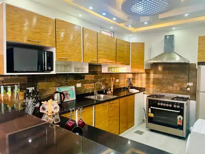 a kitchen with wooden cabinets and a sink and a stove at villa sky in Hurghada