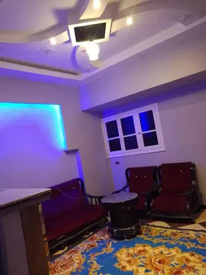 a room with a stage with purple lights and chairs at الاقصرالكرنك بجوار معبد الكرنك in Luxor