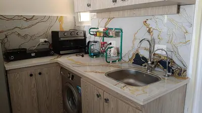 a kitchen counter with a sink and a microwave at شاليه فندقى in Hurghada