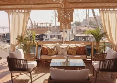 a living room with a couch and chairs and a boat at Amber Dahabiya in Luxor