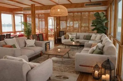 a living room with couches and tables and windows at Amber Dahabiya in Luxor