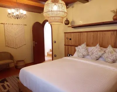 a bedroom with a white bed and a chandelier at Amber Dahabiya in Luxor