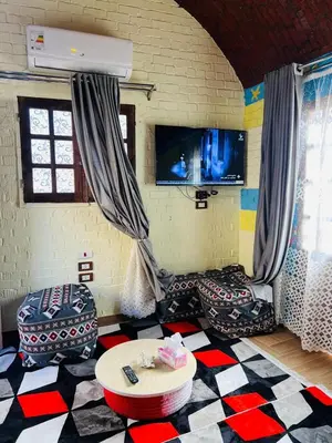 a living room with a checkered floor at Marwa House an Authentic Mud-Brick Home in Al Aqālitah