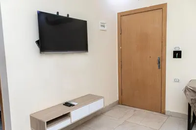 a room with a tv on the wall and a wooden door at Mirage Bay Resort Hurghada C-775 in Hurghada