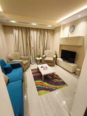 a living room with a blue couch and a table at Andalusia 101 in Hurghada