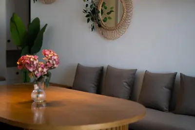 a wooden table with a vase of flowers on it at Signature Kamaran duplex 1 bed pool & views in Hurghada