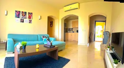 a living room with a blue couch and a table at Sahl hashesh Azzura apartment in Hurghada