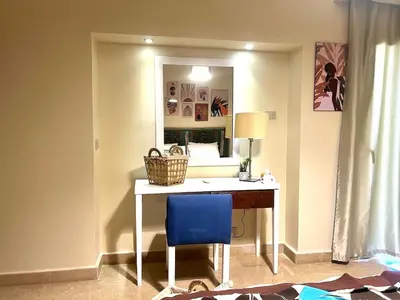 a room with a desk with a blue chair and a mirror at Sahl hashesh Azzura apartment in Hurghada