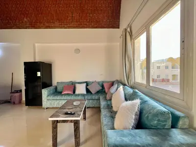a living room with a blue couch and a table at 2 bedroom flat with balcony in Hurghada