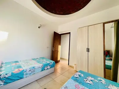 a bedroom with two beds and a mirror at 2 bedroom flat with balcony in Hurghada