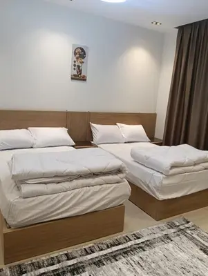a bedroom with two beds and a rug at Karma Apartment in Hurghada