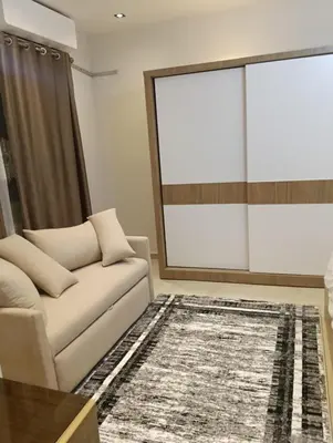 a living room with a couch and a large window at Karma Apartment in Hurghada