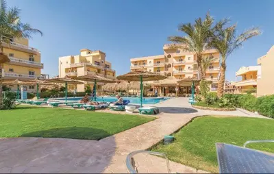 a resort with a swimming pool and some buildings at Iris Holiday Apartament in Hurghada