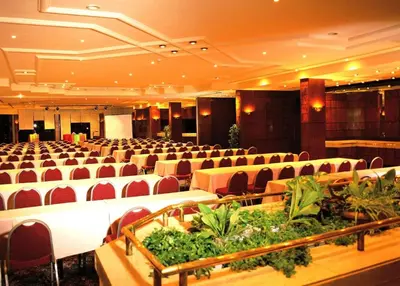 a large banquet hall with white tables and red chairs at Pyramisa Hotel Luxor in Luxor