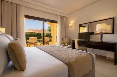 a bedroom with a bed and a desk and a piano at JAZ Solaya in Coraya Bay