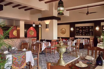 a restaurant with tables and chairs in a room at JAZ Solaya in Coraya Bay