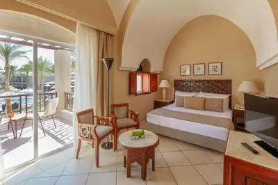 a hotel room with a bed and a balcony at Iberotel Makadi Beach in Hurghada