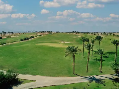 an aerial view of a golf course with palm trees at Iberotel Makadi Beach in Hurghada