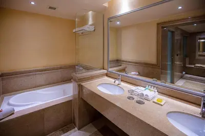 a bathroom with two sinks and a bath tub at JAZ Makadi Star & Spa in Hurghada