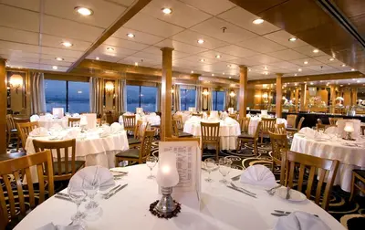 a dining room with tables and chairs with white table settings at Iberotel Luxor in Luxor