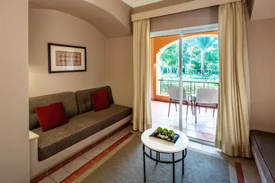 a living room with a couch and a table at JAZ Makadi Oasis Resort in Hurghada