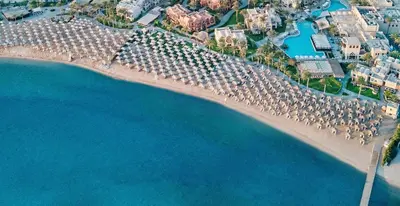 an aerial view of a beach with umbrellas and the ocean at JAZ Makadi Oasis Resort in Hurghada