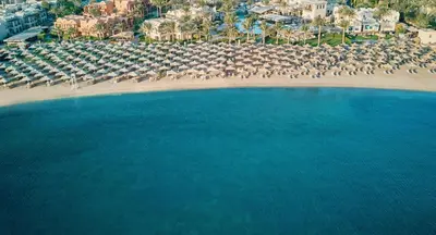 an aerial view of a beach with umbrellas and the ocean at JAZ Makadi Oasis Resort in Hurghada