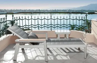 a balcony with a bench and a view of the water at Steigenberger Nile Palace Luxor - Convention Center in Luxor
