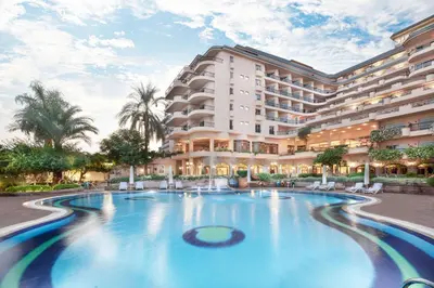 a hotel with a swimming pool in front of a building at Steigenberger Nile Palace Luxor - Convention Center in Luxor