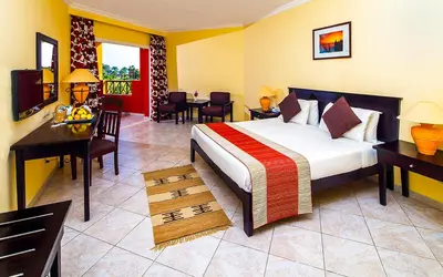 a hotel room with a bed and a table and chairs at Casa Mare Resort - ex, Royal Tulip Beach Resort in Port Ghalib