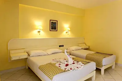 two beds in a room with yellow walls at Empire Hotel Aqua Park in Hurghada