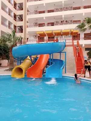 a water slide in the pool at a resort at Empire Hotel Aqua Park in Hurghada