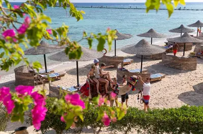 a group of people riding an elephant on the beach at Three Corners Fayrouz Plaza Beach Resort in Port Ghalib