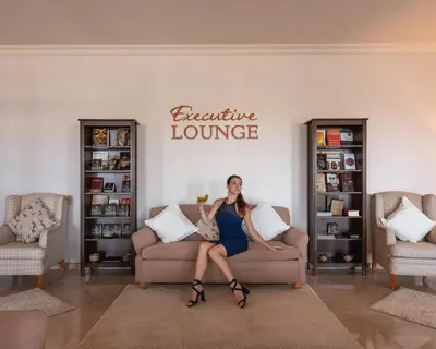a woman sitting on a couch in a living room at The Cascades Golf Resort, Spa & Thalasso in Hurghada