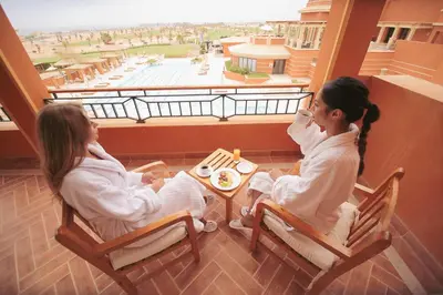 two girls sitting in chairs looking out of a window at The Cascades Golf Resort, Spa & Thalasso in Hurghada