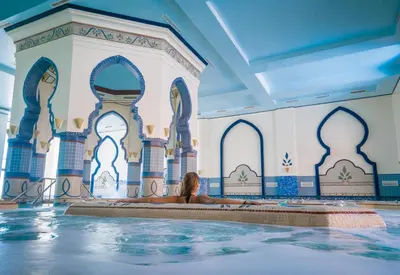 a woman laying in a hot tub in a swimming pool at The Cascades Golf Resort, Spa & Thalasso in Hurghada