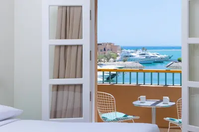 a bedroom with a balcony with a view of a boat at Captain's Inn Hotel in Hurghada