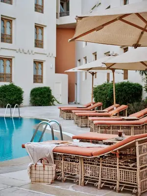 a group of chairs and umbrellas next to a pool at Ali Pasha Hotel in Hurghada
