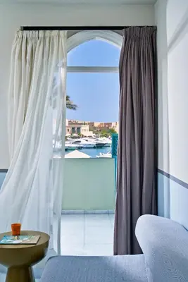 a bedroom with a window with a view of a boat at Turtle's Inn Hotel in Hurghada