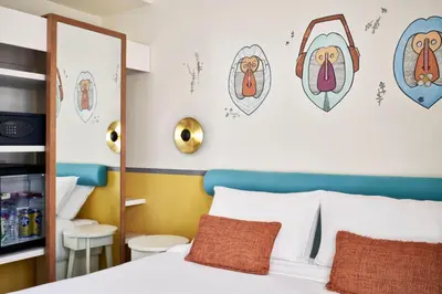 a bedroom with a bed and some drawings on the wall at Turtle's Inn Hotel in Hurghada