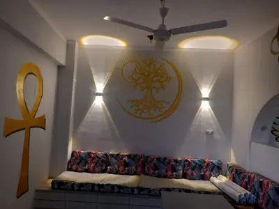 a living room with a couch and a symbol on the wall at Royal Apartments Luxor in Luxor