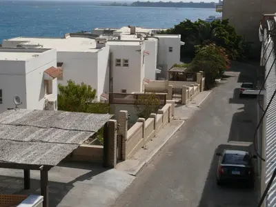 a city street with white buildings and the ocean at Mini-Studio With Free Private Beach in Hurghada