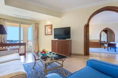 a living room with a blue couch and a tv at Kempinski Hotel Soma Bay in Hurghada