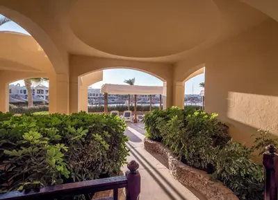 a building with arches and plants and a bench at Sunny Days Palma De Mirette Resort & Spa in Hurghada