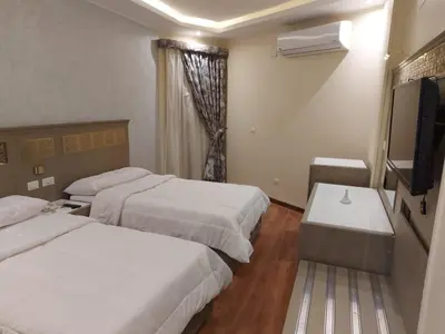 a hotel room with two beds and a flat screen tv at Lotus Luxor Hotel in Luxor