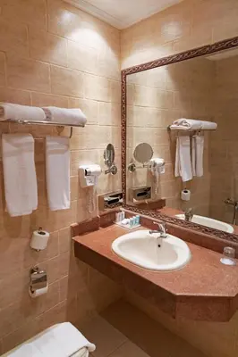 a bathroom with a sink and a mirror at Sunny Days Mirette Family Resort in Hurghada
