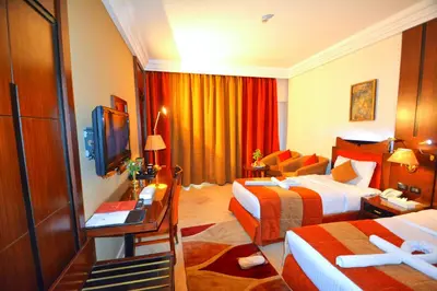 a hotel room with two beds and a couch at Aracan Eatabe Luxor Hotel in Luxor